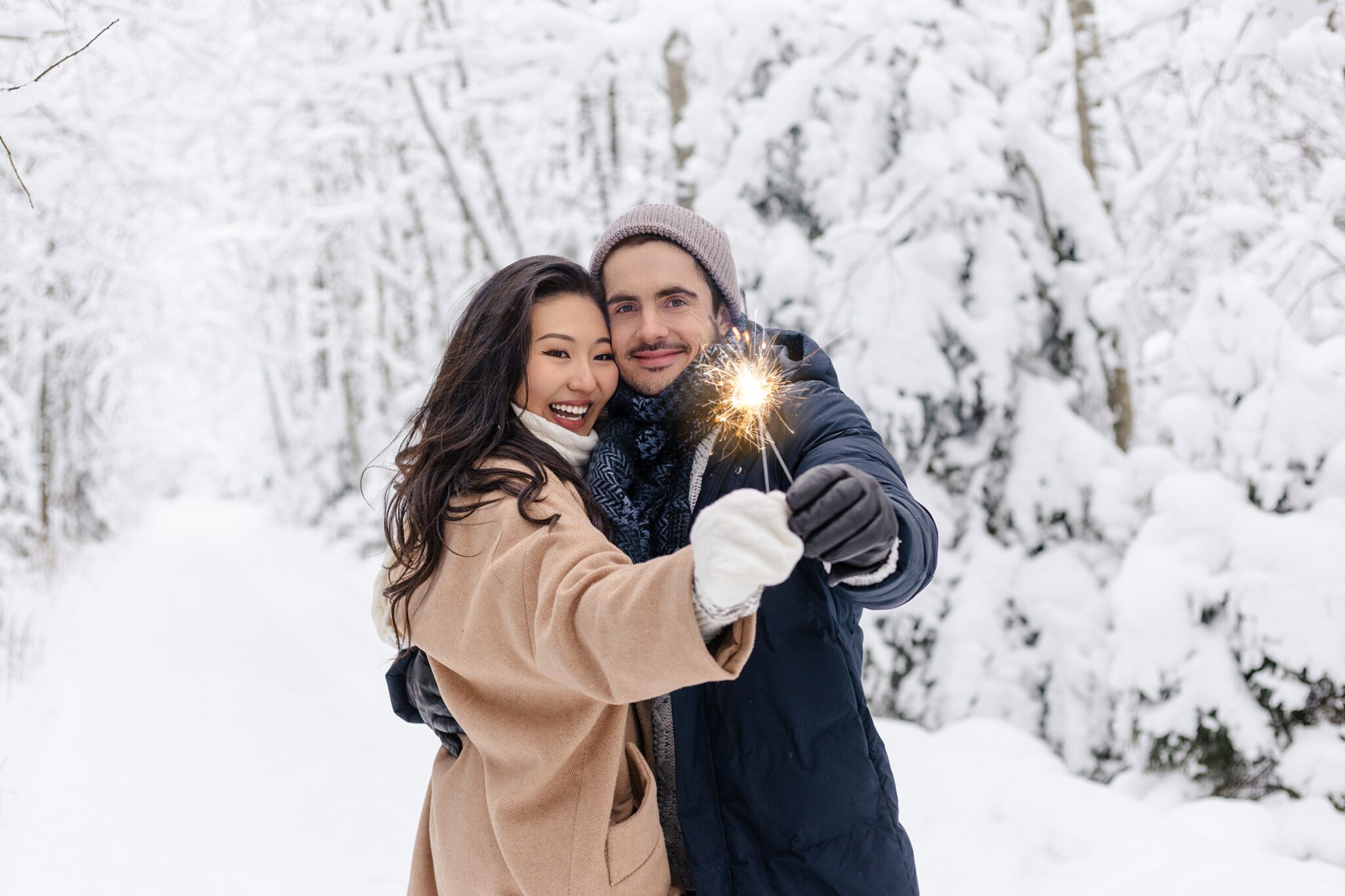 Couple holding sparklers in wintery scene
